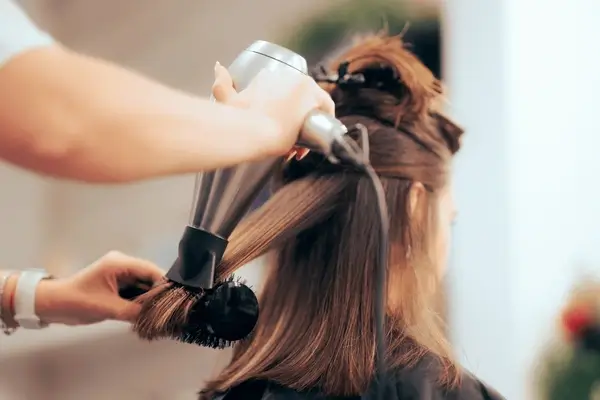 Stylist giving a professional blowout to a client